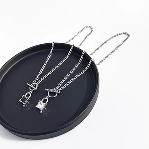 Detailed close-up of Cuban chain necklaces with square gemstone pendants and OT toggles