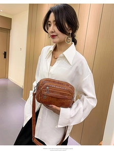 Sac bandoulière marron en similicuir avec plusieurs fermoirs porté par un mannequin