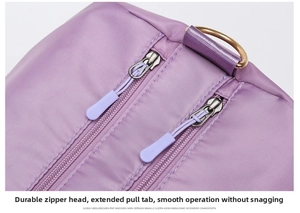 Close-up of purple travel bag with double zippers, long pullers, and golden D-ring buckle