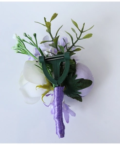 Detail view of wedding boutonniere featuring white rose and purple ribbon with safety pin