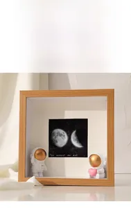 Detail of 3D shadow box frame featuring cute resin astronauts and moonlight background