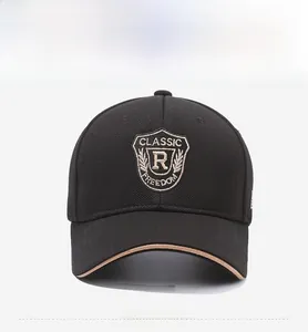 Detail of classic shield embroidery on a black twill cotton baseball cap with brown trim