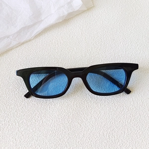 Close-up of vintage black square cat-eye sunglasses with translucent blue lenses