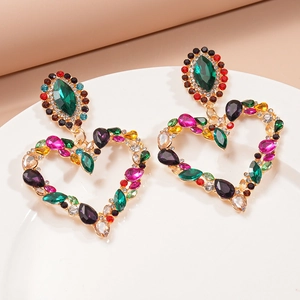 Detailed close-up of heart-shaped drop earrings with colorful rhinestones on a white plate