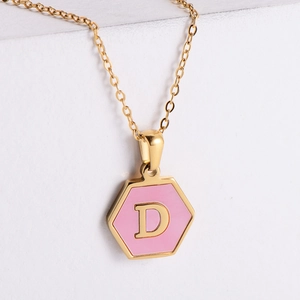 Macro shot of 18k gold plated hexagonal pendant with pink shell inlay and letter D
