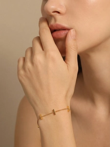 Close-up of minimalist gold plated stainless steel bar bracelet on model wrist
