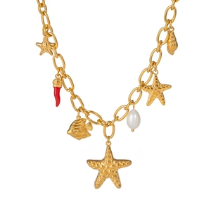 Detailed view of starfish, shell, and pearl charms on a golden beach necklace