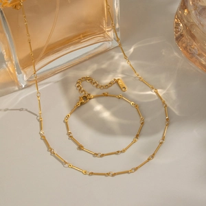 Detailed macro view of S925 engraved tag on gold-plated link necklace and bracelet