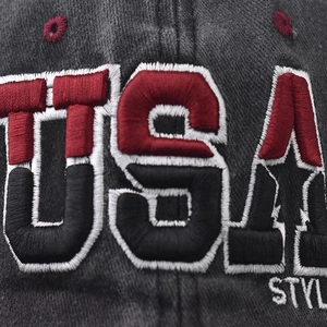 Detail of USA embroidery on vintage washed cotton baseball cap in charcoal grey