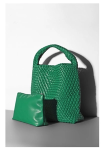 Detail of green woven bucket bag set with matching smooth leather inner pouch