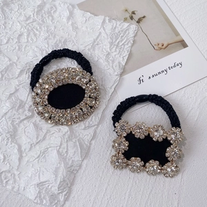 Detail of luxury rhinestone hair ties with oval and floral patterns on black elastic bands