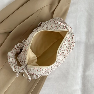 Large floral crossbody bag in cream with red prints showing spacious interior capacity