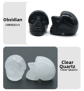 Detail view of 1-inch hand-carved skulls in natural black obsidian and clear quartz crystal