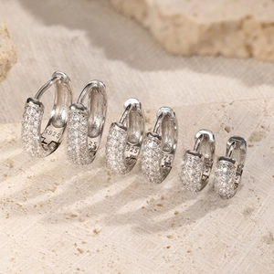 Three pairs of vintage 925 sterling silver triple-row diamond hoop earrings on stones