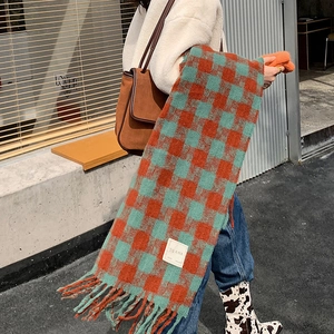 Detail of soft plaid scarf with tassels and Korean label in outdoor street style setting