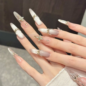 Cat eye press-on nails in nude pink gradient with 3D crystals and metal cross accents