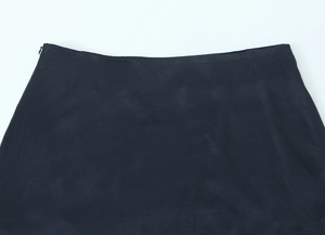Detailansicht des unsichtbaren Reißverschlusses und dunklem Satin am Minirock