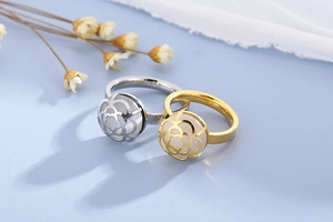 Detailed view of hollow camellia flower ring in gold and silver with iridescent opal bead