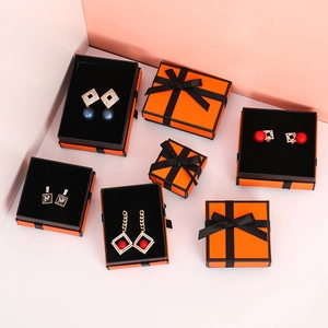 Orange jewelry gift boxes with black ribbon bows in square and rectangle sizes