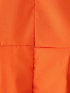 Gros plan sur le textile orange montrant la texture fine et les détails de couture