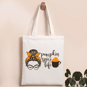 Detail of canvas tote bag featuring pumpkin spice life graphic and brown woman silhouette