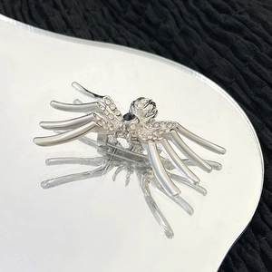 Gothic silver spider brooch with sparkling white rhinestones and a black gemstone center