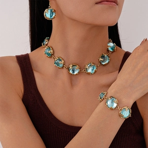 Close-up of a vintage golden necklace and earrings set with blue round resin stones