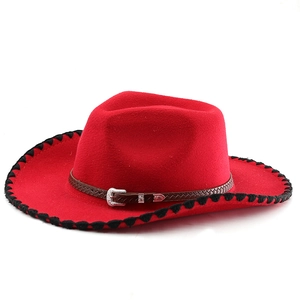 Chapeau de cowboy en feutre de laine rouge avec bandeau tressé et boucle argentée sur blanc