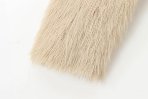 Close-up of the soft faux fur texture on a light beige long double-sided coat