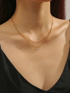Detailed view of elegant double-layered gold titanium necklace on female neck