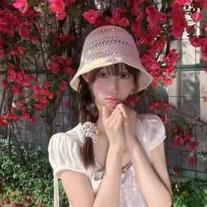 Detail of crochet hollow bucket hat in beige, showing breathable knit pattern on woman