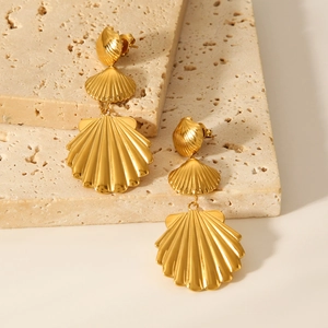 Detailed macro view of 18K gold plated stainless steel shell tiered earrings on stone base