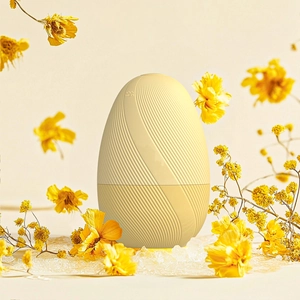 Detail of egg-shaped cream yellow aromatherapy humidifier with rippled texture and top steam vent