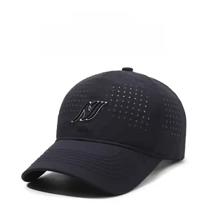 Close-up of black breathable mesh baseball cap with white embroidered logo and laser-cut holes