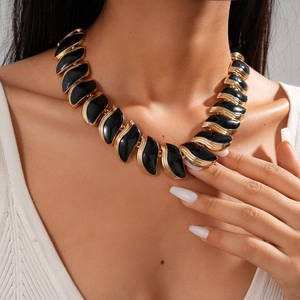 Détail du collier vintage feuilles noires avec bordures dorées ondulées sur modèle
