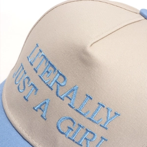 Close-up of 'LITERALLY JUST A GIRL' blue embroidery on two-tone cotton baseball cap