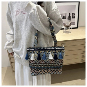 Close-up of geometric woven tote bag featuring stylish blue and white tassels