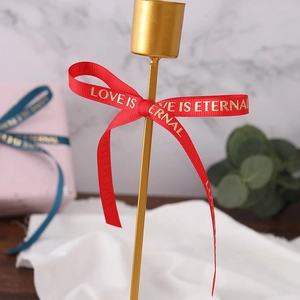 1cm red ribbon with gold LOVE IS ETERNAL lettering on a metallic gift box