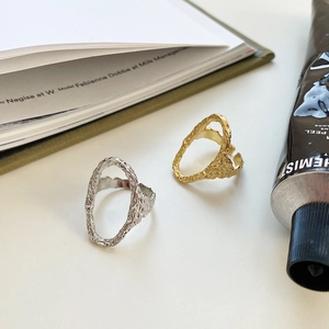 Artistic close-up of irregular molten texture rings in silver and gold finish