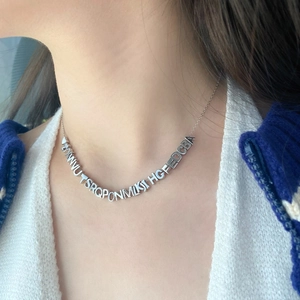 Detail of S925 sterling silver letter necklace with DIY heart pendants on female model