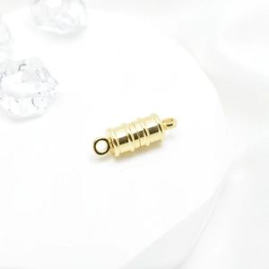 Golden bamboo-shaped magnetic clasp for DIY necklaces and bracelets on white pedestal