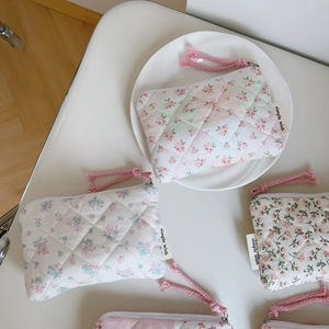 Detail of pink floral quilted fabric bag showing soft cotton texture and smooth zipper