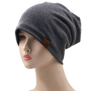 Detail of grey slouchy beanie with F&S leather label on white background