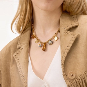 Vintage gold titanium necklace featuring resin charms and ceramic beads on female model