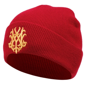 Gros plan sur le bonnet en maille rouge avec broderie dorée complexe sur le bord plié