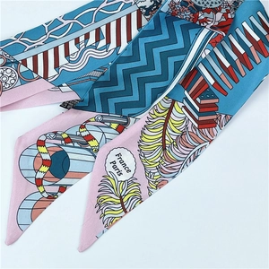 Detailed pattern of silk scarf featuring France Paris text and vibrant geometric motifs