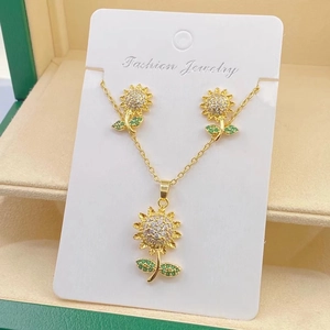 Detailed view of gold sunflower jewelry set with green crystals in a premium gift box