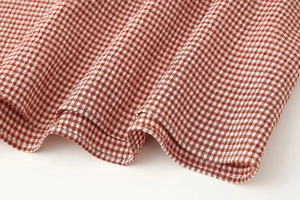 Gros plan détaillé du tissu à carreaux rouge et blanc avec couture d'ourlet soignée