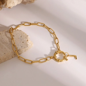Detail of gold chain bracelet with letter L pendant and large round spring clasp