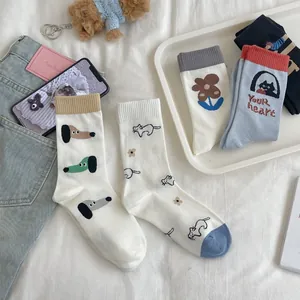 Flat lay of colorful cotton crew socks featuring cute cartoon dogs and flower patterns